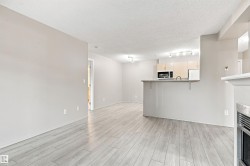 Light wood-finish flooring, recessed lighting, track lighting, light gray walls, built-in microwave - 