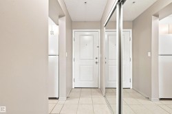 White paneled doors, mirrored sliding closet doors, tiled flooring, and light neutral wall tones - 