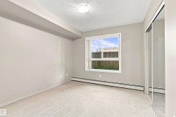 Neutral wall tones with carpet flooring, a large window, and mirrored sliding closet doors - 