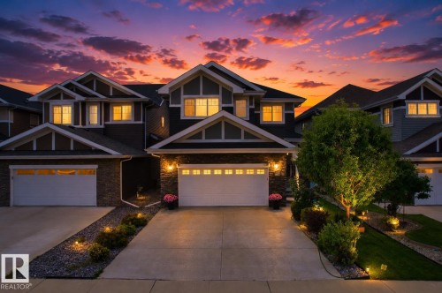 Craftsman-style exterior with stone and siding accents, dual garage doors, and a concrete driveway - 16327 17 Avenue Sw, Edmonton, AB 