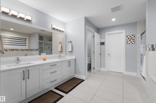 Dual vanity with integrated sinks, quartz-finish countertop, and chrome fixtures - 16327 17 Avenue Sw, Edmonton, AB 
