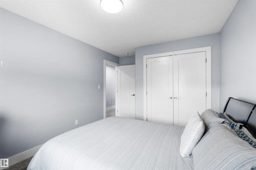 White double-door closet with chrome hardware - 16327 17 Avenue Sw, Edmonton, AB 