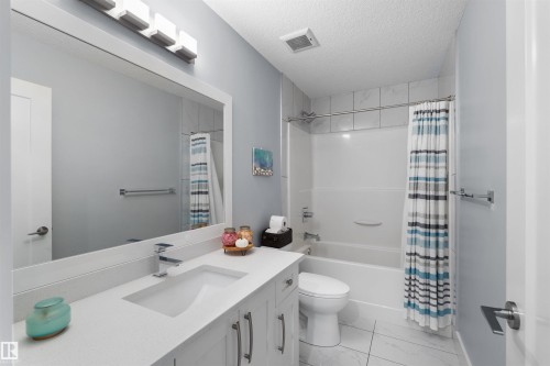 White vanity with an integrated sink, polished chrome faucet, and under-cabinet storage - 16327 17 Avenue Sw, Edmonton, AB 