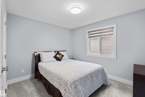 Window with horizontal blinds, flush mount ceiling light, and light gray wall paint - 16327 17 Avenue Sw, Edmonton, AB 