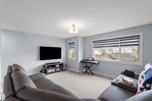 Carpeted flooring, multiple windows with blinds, recessed lighting, and a mounted ceiling fixture - 16327 17 Avenue Sw, Edmonton, AB 