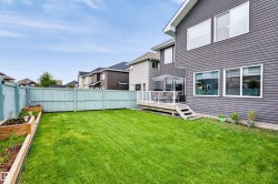 Expansive green lawn, light blue privacy fencing, and wood-finish raised garden beds - 