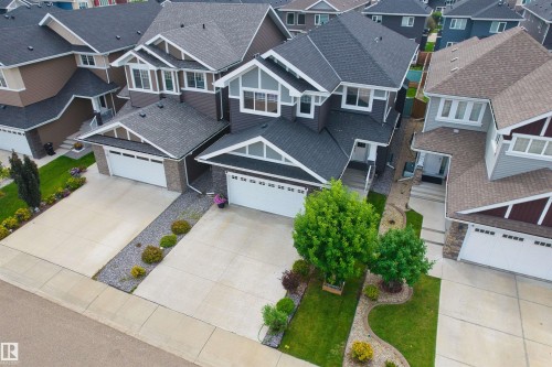 Contemporary two-story exterior with an attached two-car garage, concrete driveway, and front lawn landscaping - 16327 17 Avenue Sw, Edmonton, AB 