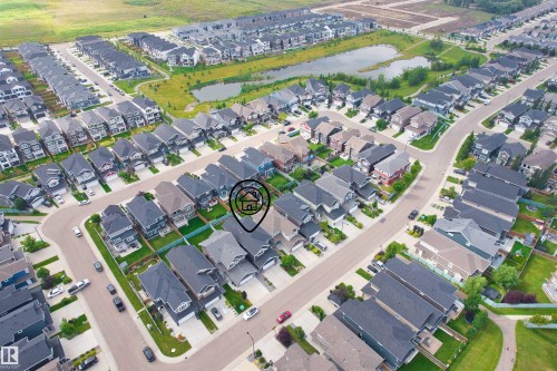 Aerial neighborhood perspective with residential streets, multiple properties, and a prominent body of water - 16327 17 Avenue Sw, Edmonton, AB 