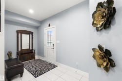Entryway with white rectangular floor tiles, a white paneled door with integrated glass, and light-colored walls - 
