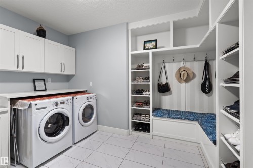 Laundry area with built-in storage, white upper cabinetry, and a countertop - 16327 17 Avenue Sw, Edmonton, AB 