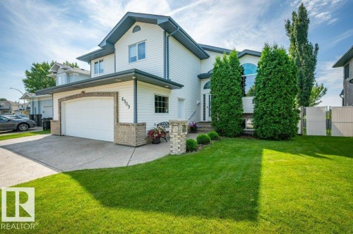 Two-story residence featuring light blue siding, white trim, and a double garage - 6909 159A Avenue Nw, Edmonton, AB - Outdoor