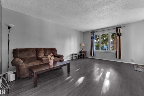 Recessed window with multiple panes, textured ceiling, and wood-finish flooring - 3425 48 Street Nw, Edmonton, AB - Indoor Photo Showing Living Room