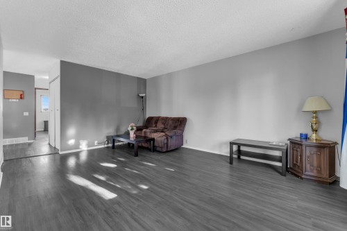 Wood-finish flooring throughout, light gray wall finishes, and a textured ceiling - 3425 48 Street Nw, Edmonton, AB - Indoor