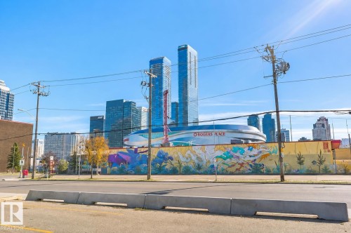 Urban streetscape with a prominent arena building and modern high-rise structures - #106 10620 104 St Nw, Edmonton, AB - Outdoor