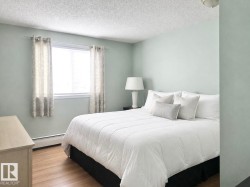 Room featuring wood-finish flooring, a window with blinds, and light-toned walls - 