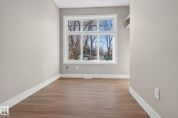 Wood-finish flooring, neutral wall tones, large multi-pane window, white window trim, and white baseboards - 