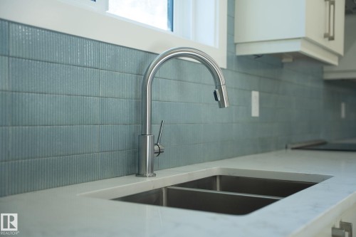 Integrated double basin stainless steel sink with a gooseneck faucet - 9736 73 Avenue Nw, Edmonton, AB 