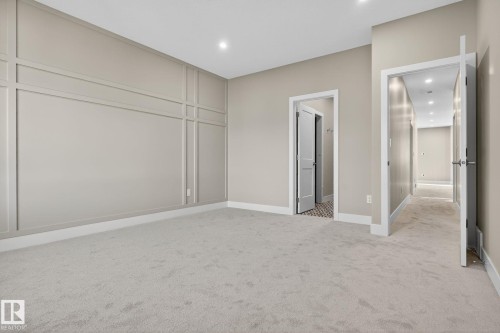 Wall paneling with integrated lighting, neutral carpet flooring, and white trim - 9736 73 Avenue Nw, Edmonton, AB 