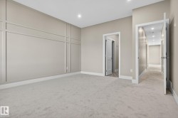 Wall paneling with integrated lighting, neutral carpet flooring, and white trim - 