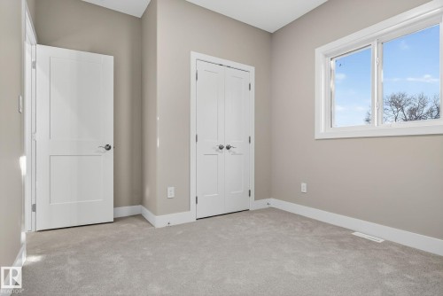 Neutral wall tones, light gray carpeting, crisp white trim, and a window with a multi-pane design - 9736 73 Avenue Nw, Edmonton, AB 
