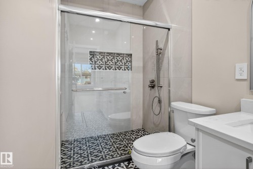 Shower with glass enclosure, decorative mosaic tile niche, and a handheld shower fixture - 9736 73 Avenue Nw, Edmonton, AB 