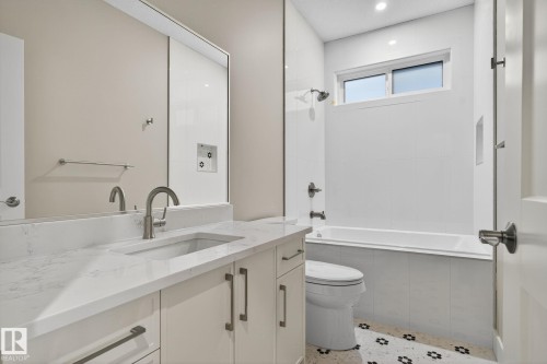 White vanity with a single basin, stone-finish countertop, and brushed nickel faucet - 9736 73 Avenue Nw, Edmonton, AB 