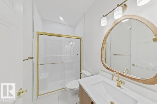 White vanity with integrated rectangular sink and gold-finish faucet - 9736 73 Avenue Nw, Edmonton, AB - Indoor Photo Showing Bathroom