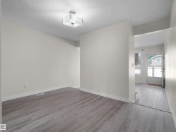 Neutral wall paint, wood-finish flooring, and a contemporary ceiling light fixture - 