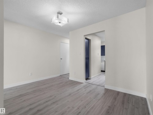 Wood-finish flooring, white walls, and a contemporary ceiling light fixture - #47 1904 48 St Nw, Edmonton, AB - Indoor Photo Showing Other Room