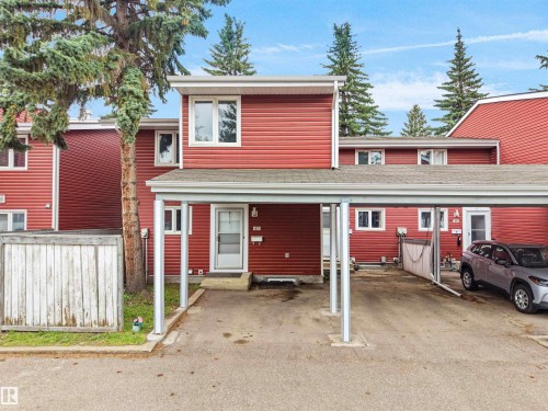 Red siding exterior with white trim, featuring a carport, multi-pane windows, and a front entry door - #47 1904 48 St Nw, Edmonton, AB - Outdoor