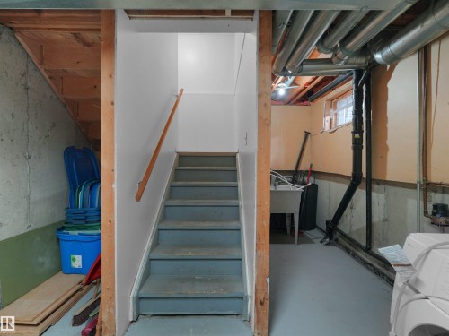 Painted concrete floor, exposed utility pipes, and visible wooden framing - #47 1904 48 St Nw, Edmonton, AB - Indoor Photo Showing Basement