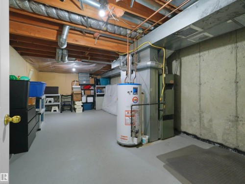 Finished basement space with exposed ceiling joists, concrete walls, and painted concrete flooring - #47 1904 48 St Nw, Edmonton, AB - Indoor Photo Showing Basement