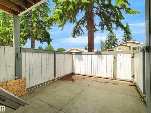 Concrete patio area with a white privacy fence and gate - #47 1904 48 St Nw, Edmonton, AB - Outdoor