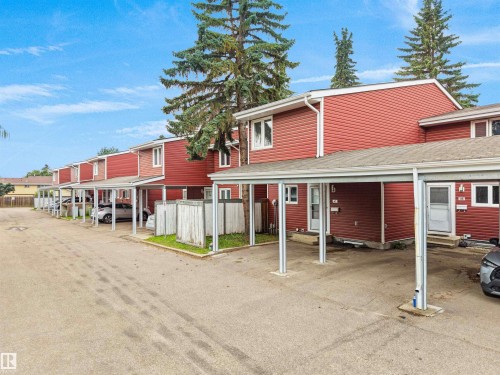 Red siding exterior, white trim, multiple carports, paved parking area, mature trees - #47 1904 48 St Nw, Edmonton, AB - Outdoor