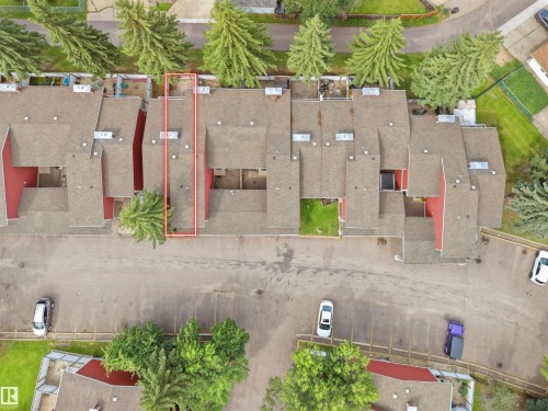 Red-sided townhome with a dark shingle roof and a dedicated parking area - #47 1904 48 St Nw, Edmonton, AB - 