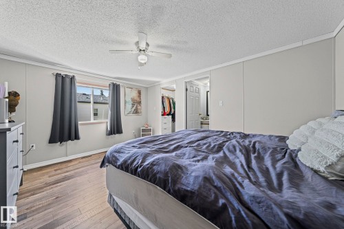 Spacious room featuring wood-finish flooring, a ceiling fan, and a window - 89 Springfield Crescent, Spruce Grove, AB 