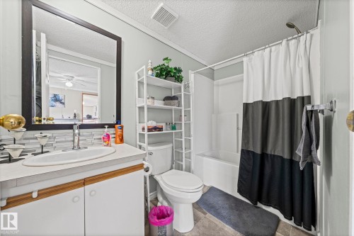 White vanity with double-door cabinetry, a drop-in sink, and a single-handle faucet - 89 Springfield Crescent, Spruce Grove, AB 
