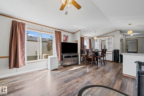 Wood-finish flooring throughout, large windows, ceiling fan, recessed built-in shelving, and built-in cabinetry - 89 Springfield Crescent, Spruce Grove, AB 