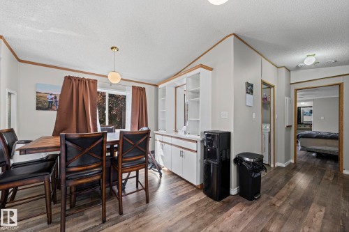 Wood-finish flooring throughout, with a built-in white cabinetry unit featuring open shelving - 89 Springfield Crescent, Spruce Grove, AB 
