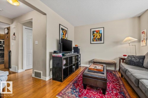 Hardwood-style flooring throughout, neutral wall tones, and recessed ceiling lighting - 11436 88 Street Nw, Edmonton, AB - Indoor Photo Showing Living Room
