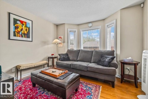 Hardwood-finish flooring, bay window with blinds, and neutral wall paint - 11436 88 Street Nw, Edmonton, AB - Indoor Photo Showing Living Room