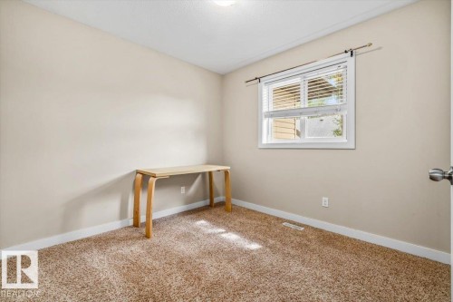 Neutral-toned carpeting, light-colored walls, and a window with blinds - 11436 88 Street Nw, Edmonton, AB - Indoor Photo Showing Other Room