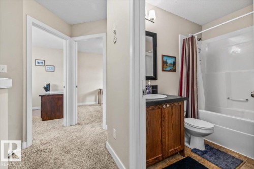 Bathroom featuring a wood-finish vanity with an integrated sink and a shower-over-tub combination - 11436 88 Street Nw, Edmonton, AB - Indoor Photo Showing Bathroom
