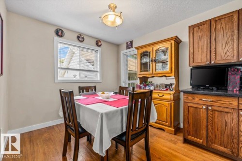 Wood-finish flooring, warm neutral wall tones, and a single window with blinds - 11436 88 Street Nw, Edmonton, AB - Indoor Photo Showing Dining Room