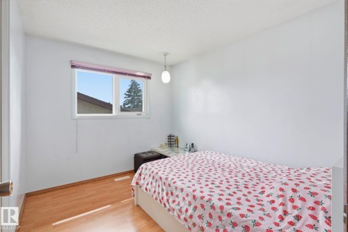 Wood-finish flooring with white walls and a window featuring a white frame - 10007 168 Avenue Nw, Edmonton, AB - Indoor Photo Showing Bedroom