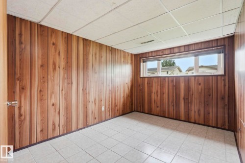 Wood-finish wall paneling, tiled flooring, drop ceiling, and a horizontal window - 10007 168 Avenue Nw, Edmonton, AB - Indoor Photo Showing Other Room