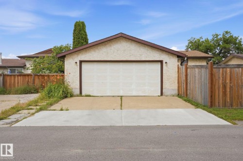 Detached garage with stucco exterior, a gable roof, and a panel garage door - 10007 168 Avenue Nw, Edmonton, AB - Outdoor With Exterior