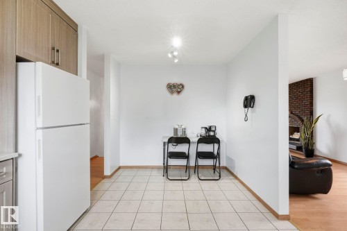Built-in cabinetry, tile flooring, track lighting, and a partial brick-faced wall - 10007 168 Avenue Nw, Edmonton, AB - Indoor