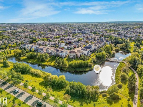 Residential neighborhood with a prominent water feature, surrounded by mature trees and paved walking paths - 1142 Barnes Way Sw, Edmonton, AB - Outdoor With View