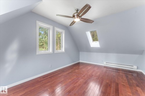 Hardwood flooring, sloped ceiling, two windows, skylight, and ceiling fan with integrated lighting - 2, 59031 Range Rd 232, Rural Thorhild County, AB - Indoor Photo Showing Other Room